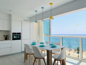 uma cozinha e sala de jantar com mesa e cadeiras em Seafront New Apartment Boutique em Lloret de Mar