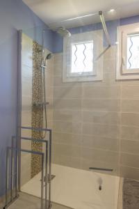 een glazen douche in een badkamer met een raam bij maison garrigue piscine hors sol pétanque in Pignan