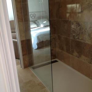 a bathroom with a shower with a bed in the background at Villa Prétorina in Cannes