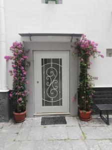 una puerta delantera con dos macetas y un banco en LuRe Holiday Napoli 2, en Nápoles