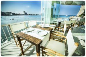 a table on a balcony with a view of the beach at Hotel Muva Beach in Peñíscola