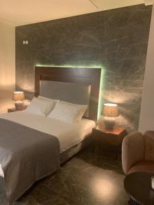 ein Schlafzimmer mit einem Bett, einem Sofa und einem Stuhl in der Unterkunft Tabar Hotel in Nazareth