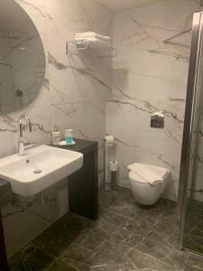 a bathroom with a sink and a toilet and a mirror at Tabar Hotel in Nazareth