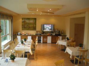 un ristorante con tavoli e sedie bianchi e una cucina di Hotel Pit Lane "Home of Motorsport" a Nürburg