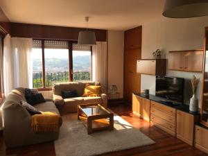 a living room with a couch and a tv at Gibeleburu in Bermeo