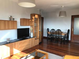 sala de estar con TV y mesa de comedor en Gibeleburu, en Bermeo