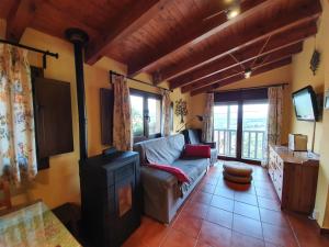 a living room with a couch and a tv at Aptos. Rurales Los Falares de la Abuela Berta (Adults Only) in Nieda