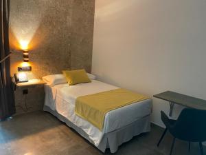 ein kleines Schlafzimmer mit einem Bett und einem Tisch in der Unterkunft HOTEL Boutique ÁNGEL in Santa Cruz de Mudela + 37 Fotos