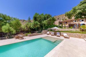 una piscina con sillas y una casa en Villa Can Suau Petit, en Port de Pollença (Puerto Pollensa)