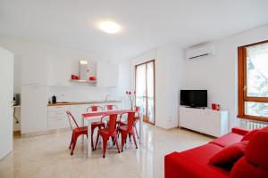 un soggiorno con tavolo, sedie e divano rosso di Dodo Red - The House Of Travelers a Como