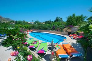 a swimming pool with chairs and a fountain at Villa Carla by Sealand Villas in Port de Pollensa