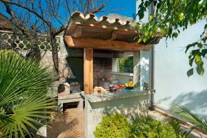 an outdoor kitchen with a wooden pergola at Villa Carla by Sealand Villas in Port de Pollensa