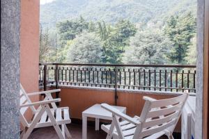 2 sedie e un tavolo sul balcone con vista di Dodo Red - The House Of Travelers a Como