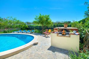 a backyard with a swimming pool and a patio with a barbecue at Villa Tomeu by Sealand Villas in Port de Pollensa