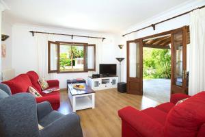 a living room with red couches and a television at Villa Tomeu by Sealand Villas in Port de Pollensa