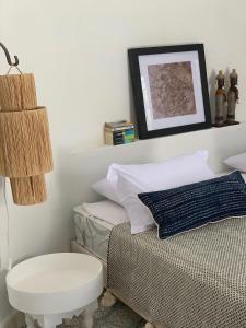 a bedroom with a bed with a stool and a picture at Les Jardins de Villa Maroc in Essaouira