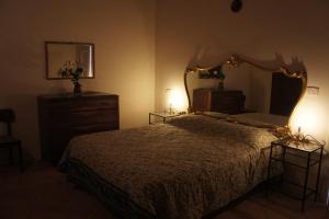 ガンバッシ・テルメにあるVilla Borgo la Fungaiaのベッドルーム(ベッド1台、大きな鏡付)