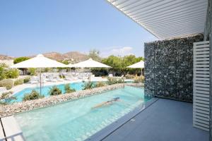 a person swimming in the pool at a resort at Relux Ios Hotel in Ios Chora