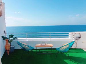 two chairs and a table on a balcony with the ocean at Respirar in Peñíscola