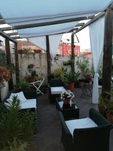 a patio with couches and a canopy with plants at Borgo Marinaro in Aci Castello