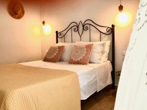 a bedroom with a bed with white sheets and pillows at Unique Anoi House - In the Heart of Skyros Village in Skiros