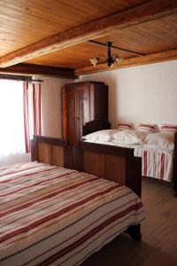 1 dormitorio con 2 camas y techo de madera en Retro Vendégház, en Nagyharsány