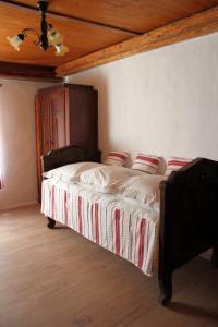 a bedroom with a large bed with a wooden ceiling at Retro Vendégház in Nagyharsány