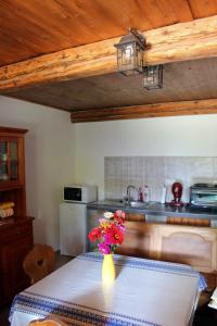 a kitchen with a table with a vase of flowers on it at Retro Vendégház in Nagyharsány