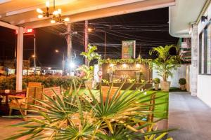 a patio at night with palm trees and plants at Thap Sakae Hotel in Thap Sakae