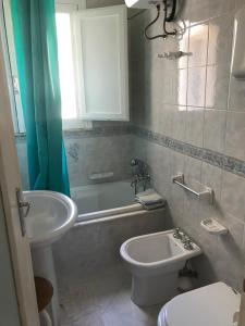 a bathroom with a sink and a toilet and a tub at Casa vacanze levanzo in Levanzo
