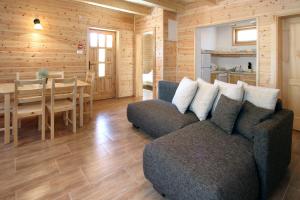 ein Wohnzimmer mit einem Sofa und einem Esszimmer in der Unterkunft Family Panzio es Apartman Hazak in Lipót