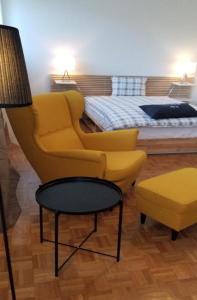 Un dormitorio con una silla amarilla y una cama en HSH Barre 6 - City Apartment next Cathedral Lausanne en Lausana
