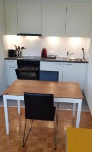cocina con mesa de madera y 2 sillas en HSH Barre 6 - City Apartment next Cathedral Lausanne, en Lausana