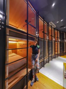 a woman is standing in a row of lockers at The Bed KLCC in Kuala Lumpur