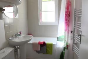 een badkamer met een wastafel en een bad bij L'albatros in Dieppe