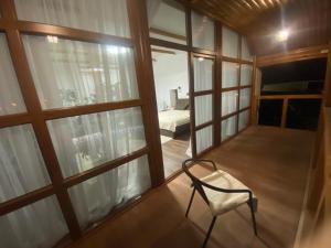 einen Stuhl in einem Zimmer mit großen Fenstern in der Unterkunft Kozak's Dream in Kamjanez-Podilskyj