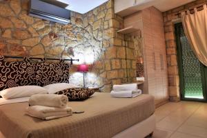 a bedroom with a large bed with a stone wall at Messinian Horizons in Marathopoli +80 photos