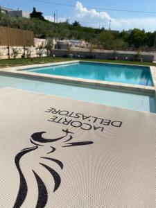 um sinal em frente a uma piscina em Resort La Corte Dell'Astore - Wild in Style Resort em Alberobello