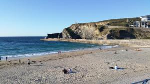 a group of people on a beach near the ocean at Wesley House Holidays - Choice of 2 Quirky Cottages in 4 private acres in Redruth