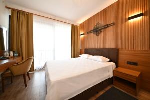 a bedroom with a bed and a desk and a window at 1774 Kazdağı Termal Otel in Ilija +17 photos
