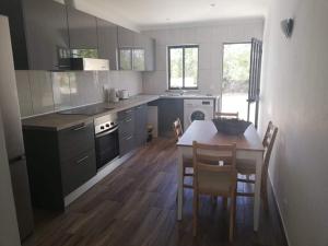 a kitchen with a table and some chairs in it at Casa no Campo in Algoz