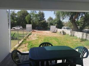 una mesa y sillas en un porche con vistas a un campo en Casa no Campo en Algoz