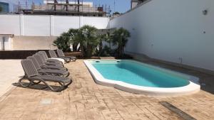 una piscina con sedie a sdraio accanto a un edificio di B&B RESORT SIGNORILE a Bari