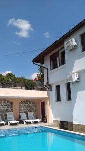 une villa avec une piscine à côté d'un bâtiment dans l'établissement Guest House Harmony, à Veliko Tarnovo