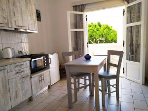 a kitchen with a table and chairs and a microwave at Xenios Dias in Matala