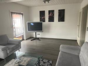 a living room with a couch and a flat screen tv at Ferienwohnung Ulmbach -Sterntaler- in Steinau an der Straße