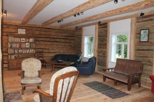 a living room with wooden walls and furniture and chairs at Zirgu sēta "Klajumi" - Horse ranch "Klajumi" in Kaplava