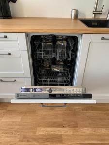 a dishwasher with its door open in a kitchen at Piiri Apartment in Rakvere