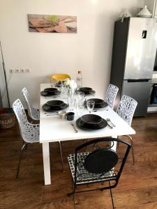 a white table with chairs and plates on it at Entre Neige et Thermes in Brides-les-Bains