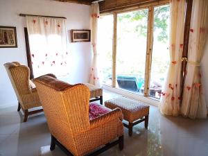 a living room with chairs and a large window at Phu Chaisai Mountain Resort in Mae Salong Nai